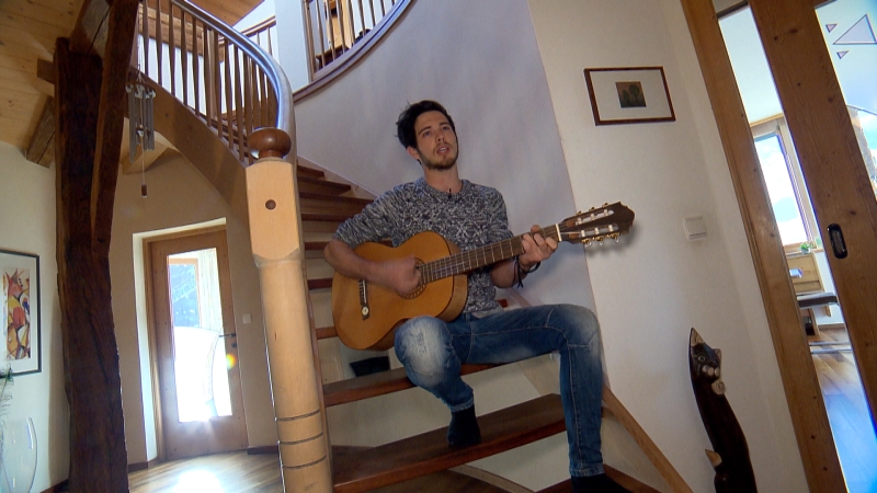 Klaus Holzmann spielt bei sich im Haus auf der Treppe Gitarre