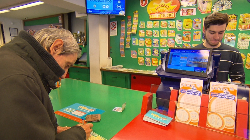 Ein Mann füllt in der Lottoannahmestelle seinen Schein aus, im Hintergrund ist der Jackpot zu sehen: 100.900.000 Euro