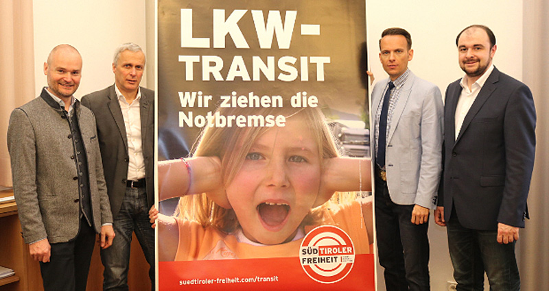 Vorstellung des Werbeplakats LKW-Transit - Wir ziehen die Notbremse der Bewegung "Süd-Tiroler Freiheit", Parteivertreter stehen neben dem Plakat