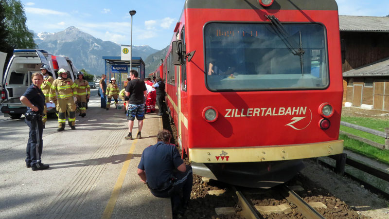 Zillertalbahn, ein Polizist begutachtet die Bahn, Passanten und Rettungskräfte