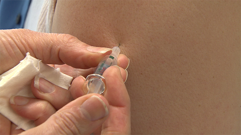 Impfung mit Spritze in Oberarm