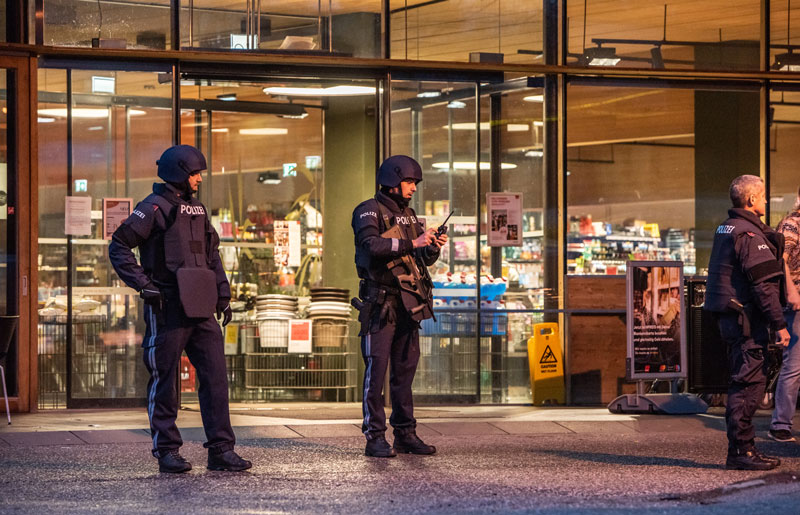 Zwei Polizisten vor dem Eingang des überfallenen Supermarktes